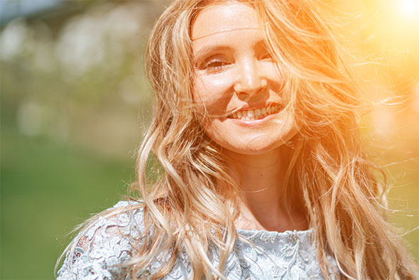GLP-1 medication results highlighted by a joyful young woman smiling in the golden sunlight.