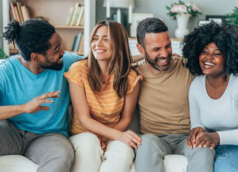 Jeuveau Botox promotes youthful appearance, as smiling diverse friends enjoy time together on a couch.