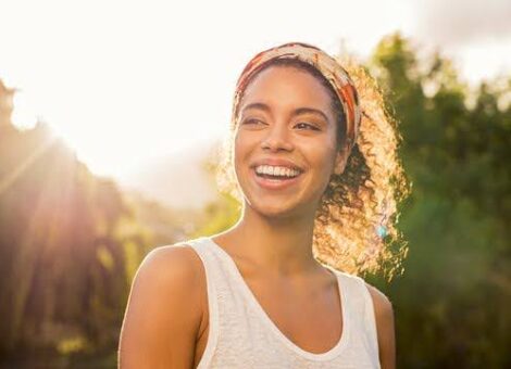 GLP-1 weight loss benefits shown by a happy woman glowing in the sunlight after outdoor activity.