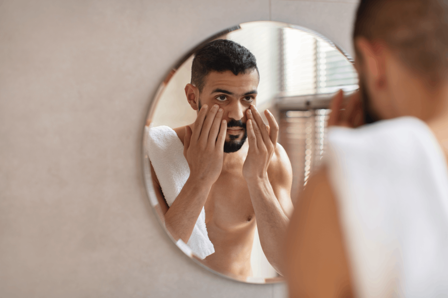 mand looking in bathroom mirror after having broadband light therapy session