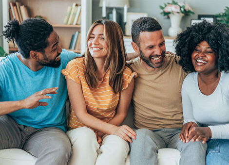 Jeuveau Botox promotes youthful appearance, as smiling diverse friends enjoy time together on a couch.