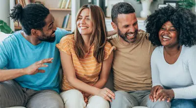 Jeuveau Botox promotes youthful appearance, as smiling diverse friends enjoy time together on a couch.