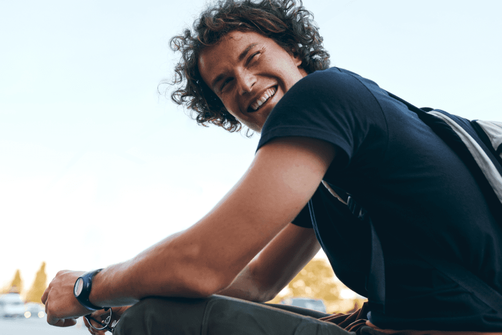 Testosterone therapy symbolized by a smiling young man outdoors with strong, healthy energy.