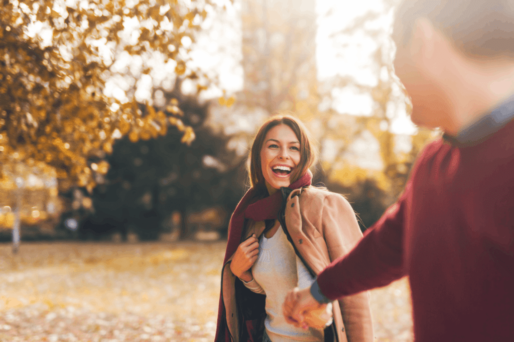 Restoring hormone health represented by a happy couple walking outdoors, holding hands and smiling.