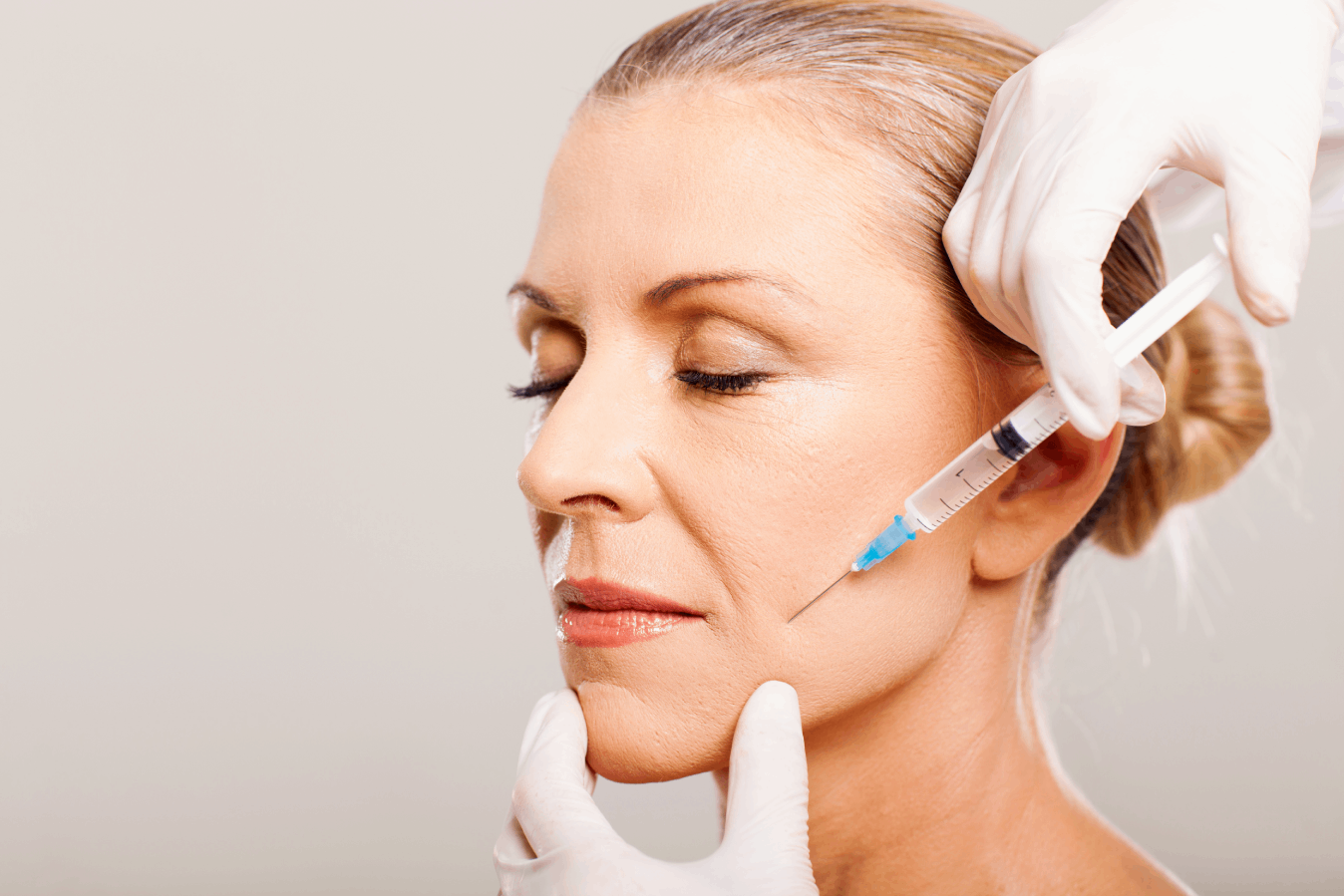 woman getting a shot of Skinvive dermal fillers around her frown lines.