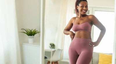 Confident woman admiring her figure in the mirror, possibly using peptides for weight loss.