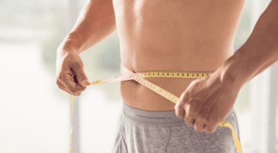 Man measuring his waist after Semaglutide weight loss