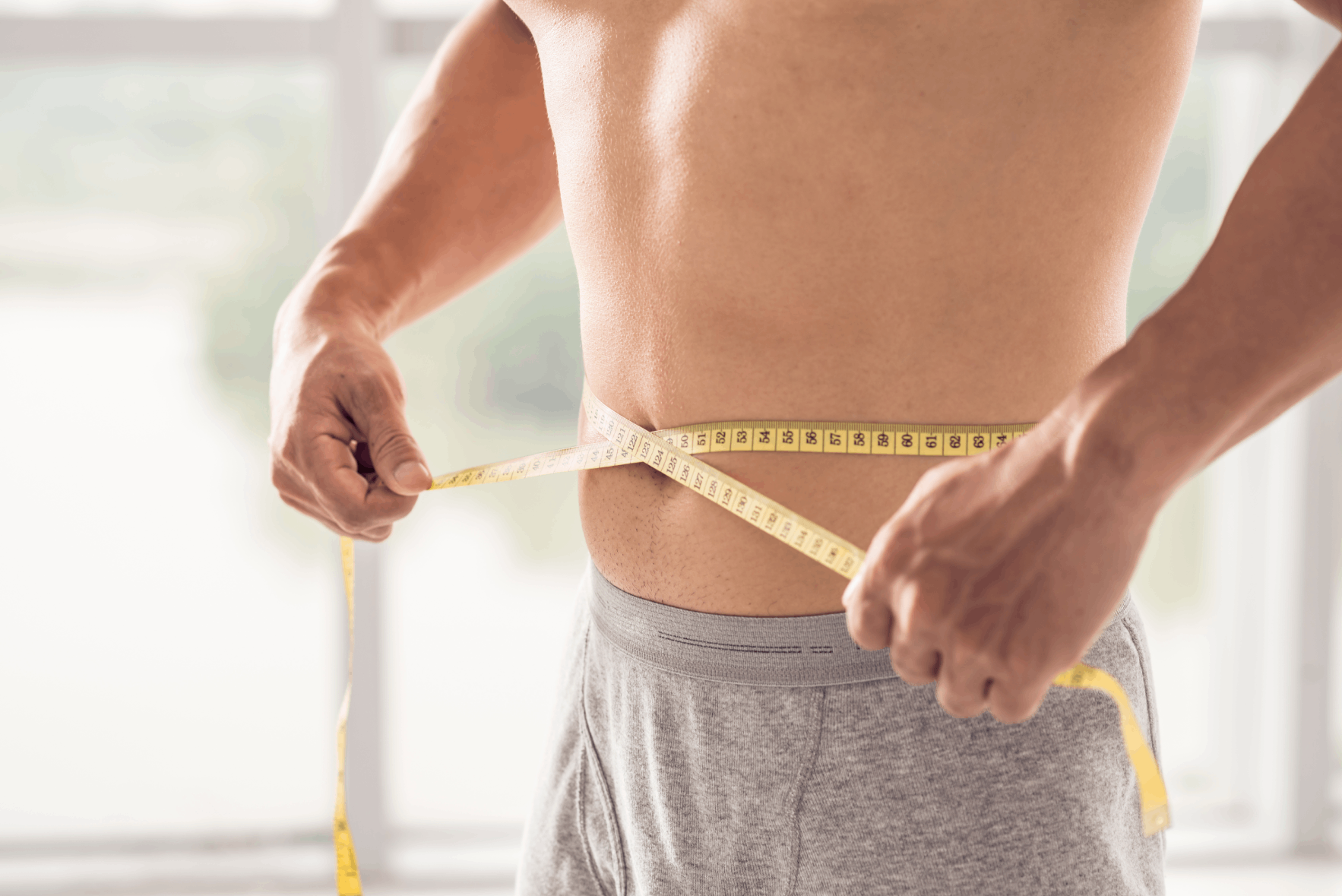 Man measuring his waist after Semaglutide weight loss