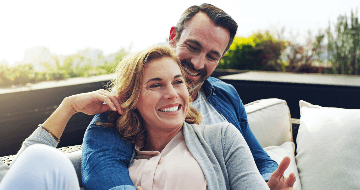 Man and woman laying on an outdoor couch after using peptide therapy together.