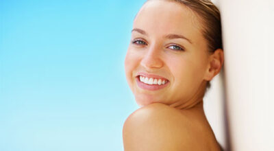 Natural appetite suppressant benefits shown by a woman smiling confidently against a bright blue background.