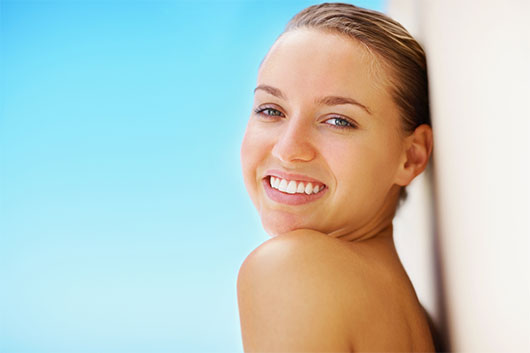 Natural appetite suppressant benefits shown by a woman smiling confidently against a bright blue background.