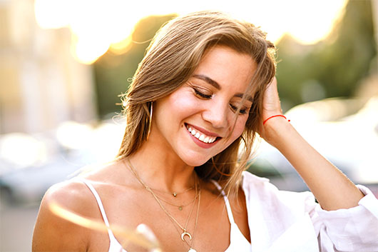 Light therapy for skin shown during a relaxing facial treatment using a glowing handheld device.