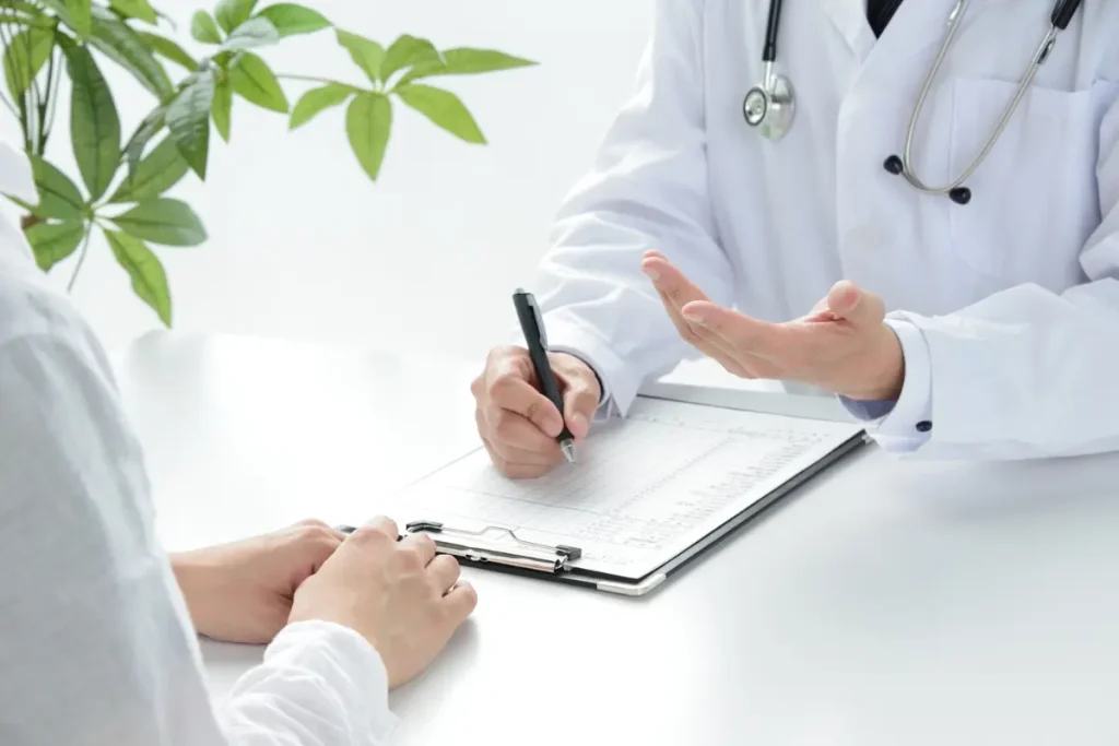 Wellness consultation with a doctor in a white coat writing notes on a clipboard while reviewing a patient's health profile.